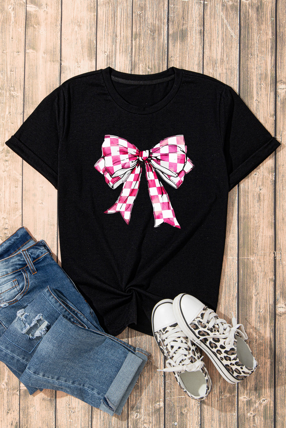 Black t-shirt with a pink and white gingham bow graphic, crew neck, short sleeves.