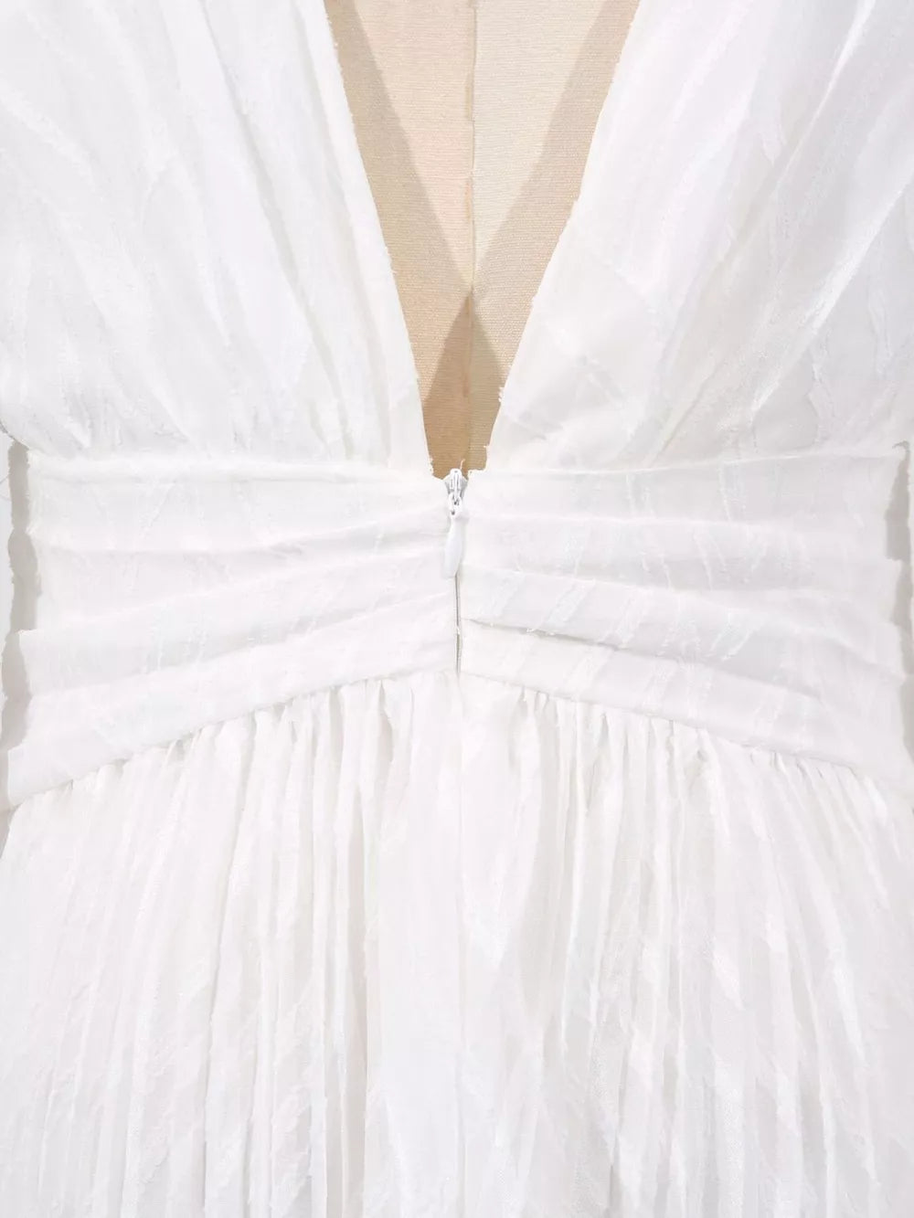 White maxi dress with ruched waist, V-neckline, and textured fabric.