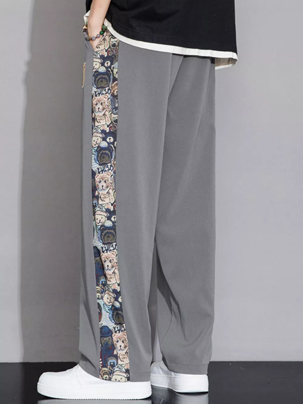 Men's light gray sweatpants with a printed side stripe featuring cartoon bears.