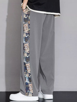 Men's light gray sweatpants with a printed side stripe featuring cartoon bears.