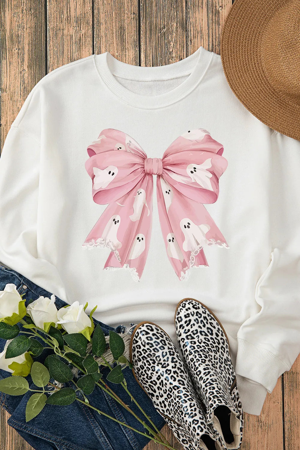 White crewneck sweatshirt with a pink bow graphic adorned with cute ghosts.