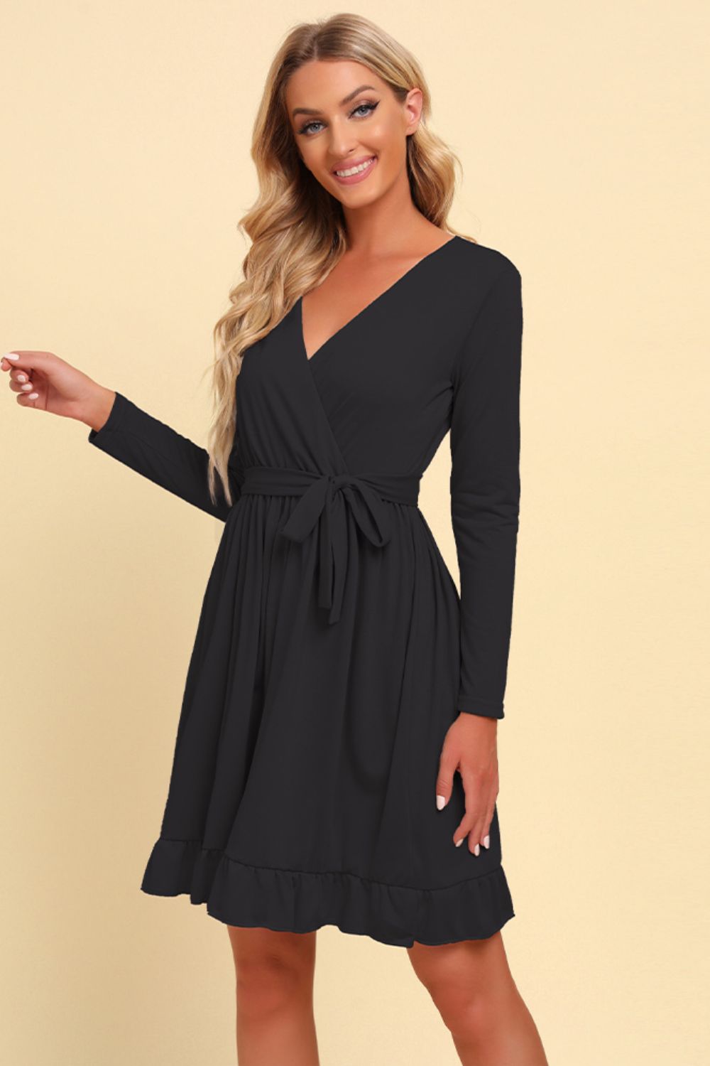 Black wrap dress with long sleeves, tie waist, and ruffled hem.