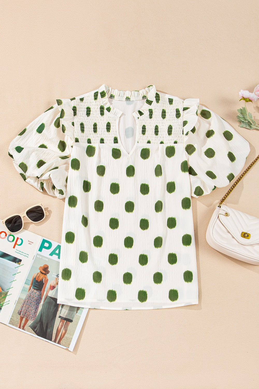 Textured polka dot blouse in white with green dots, smocked yoke, and puff sleeves.