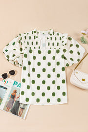 Textured polka dot blouse in white with green dots, smocked yoke, and puff sleeves.