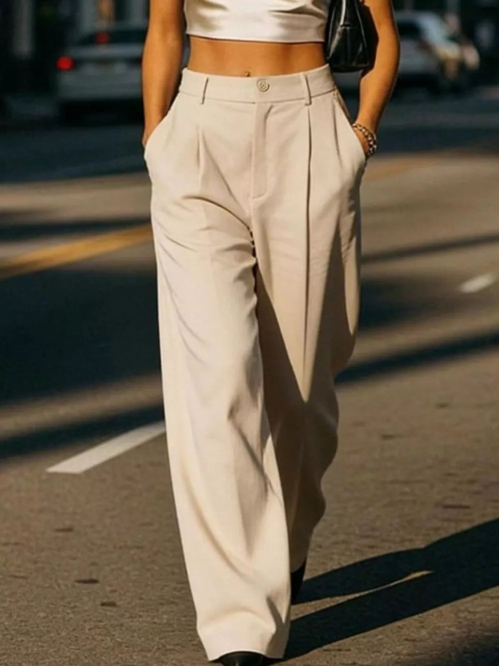 Cream high-waisted pleated wide-leg maternity trousers with button closure and pockets.