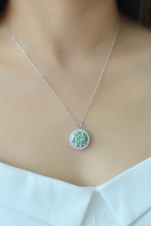 Green moissanite halo necklace in platinum with a round cut center stone.
