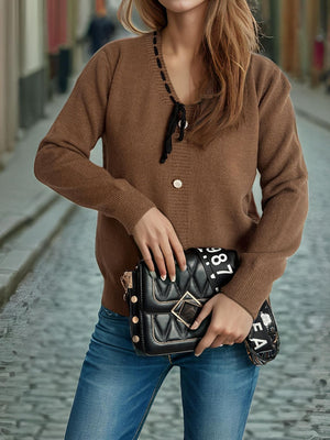 Brown knit cardigan with black ribbon trim and tie detail, button front, long sleeves.