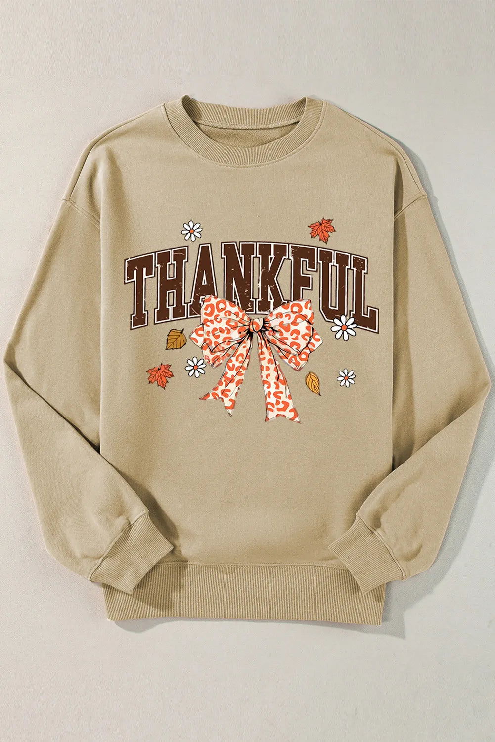 Khaki sweatshirt with "THANKFUL" graphic, leopard print bow, and fall leaves.