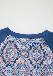 Dusty blue bohemian print blouse with bell sleeves and a crew neck.