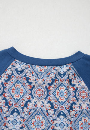 Dusty blue bohemian print blouse with bell sleeves and a crew neck.