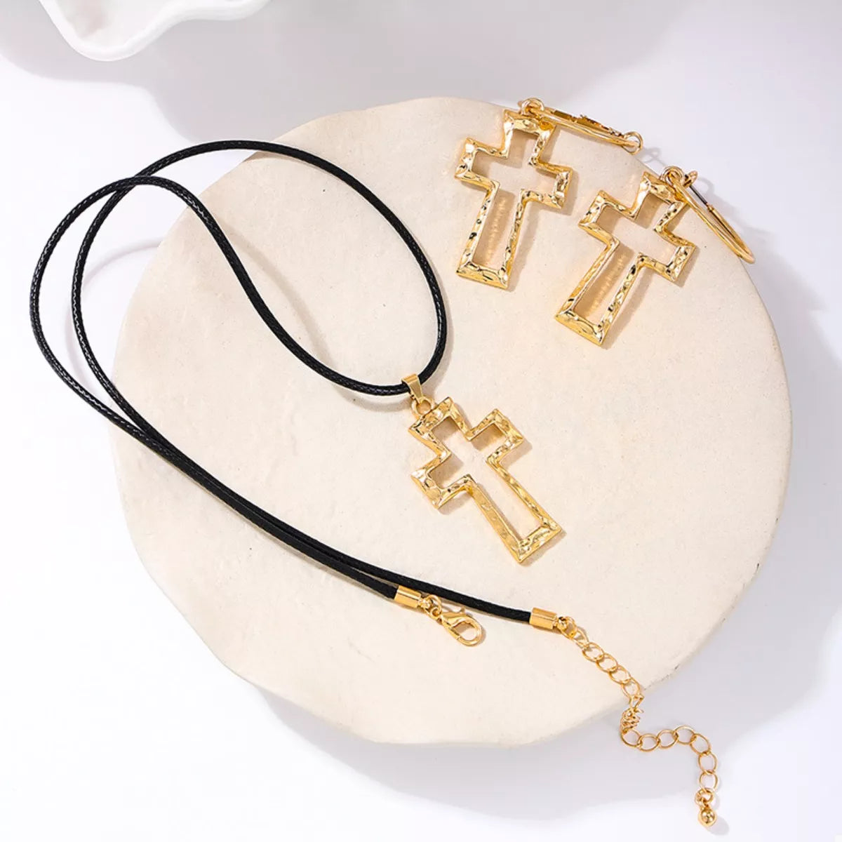 Golden cross pendant necklace with black cord and matching earrings, 18K gold-plated.