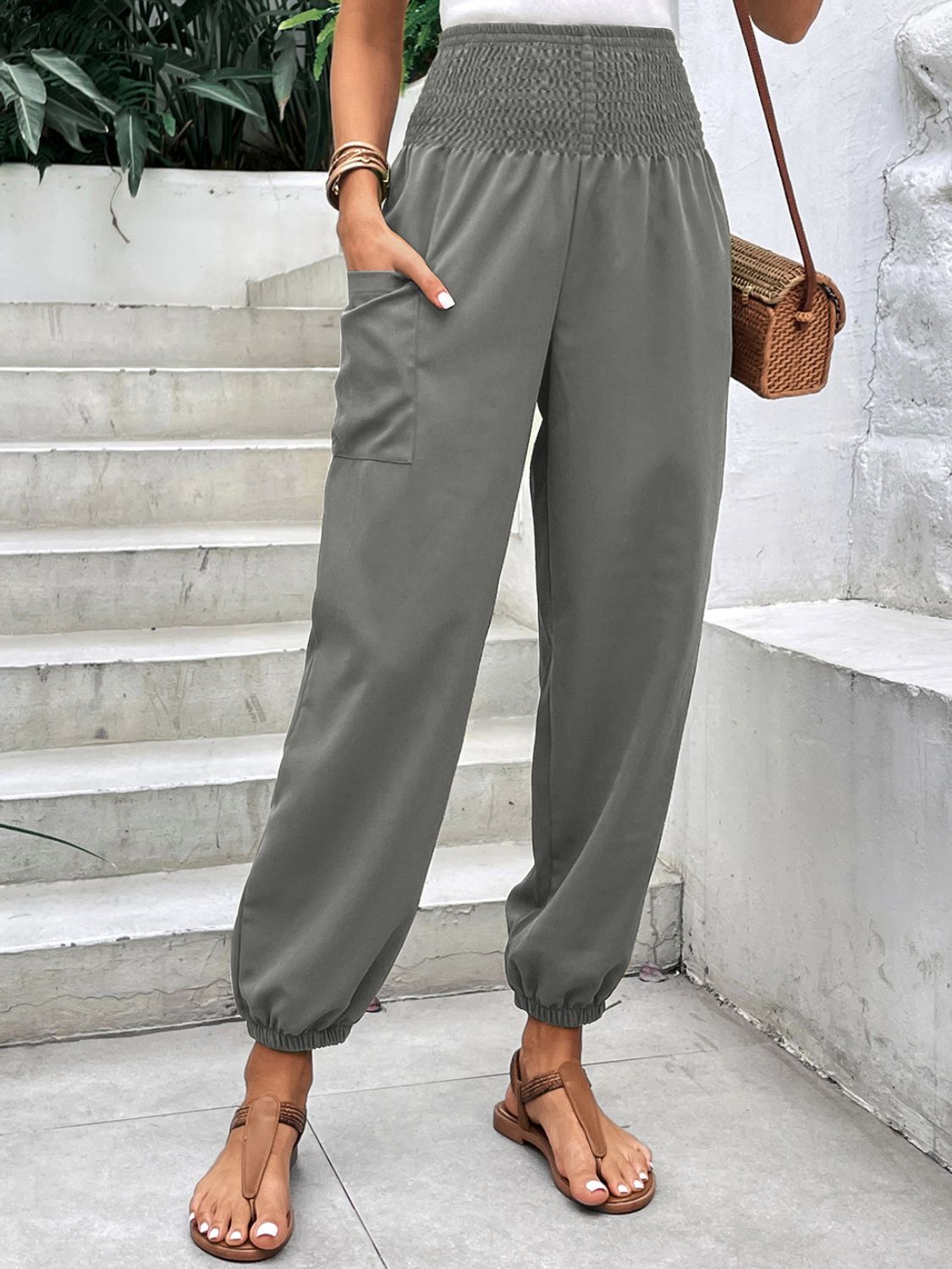 Gray relaxed-fit cargo pants with smocked waist and cinched ankles.