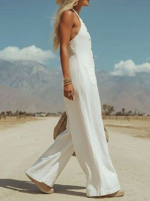White halter neck jumpsuit with button front and pockets, wide leg.