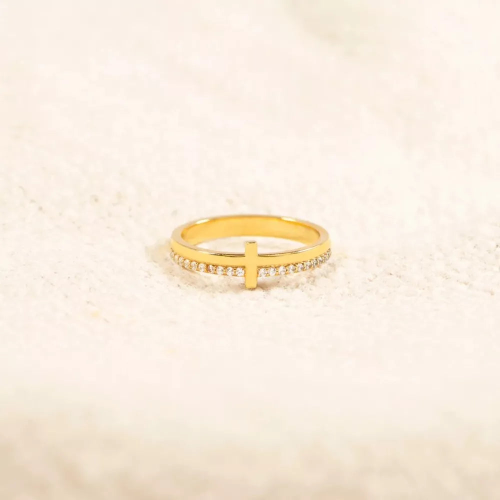 Gold-plated ring with a delicate cross and pave crystal band.