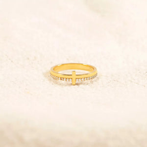 Gold-plated ring with a delicate cross and pave crystal band.