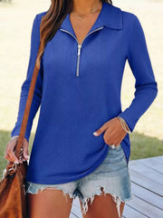 Blue ribbed knit long sleeve top with half-zip collar and silver zipper detail.