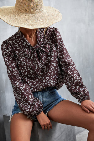 Brown abstract heart print pussy bow blouse with balloon sleeves.