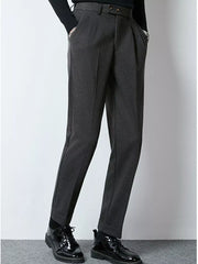 Men's dark gray tailored pleated dress pants with cuffed hems.