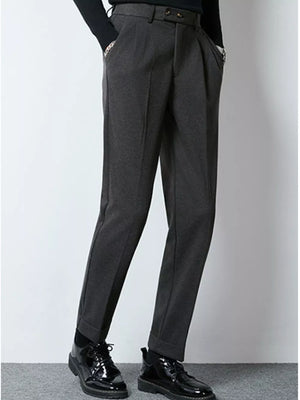 Men's dark gray tailored pleated dress pants with cuffed hems.