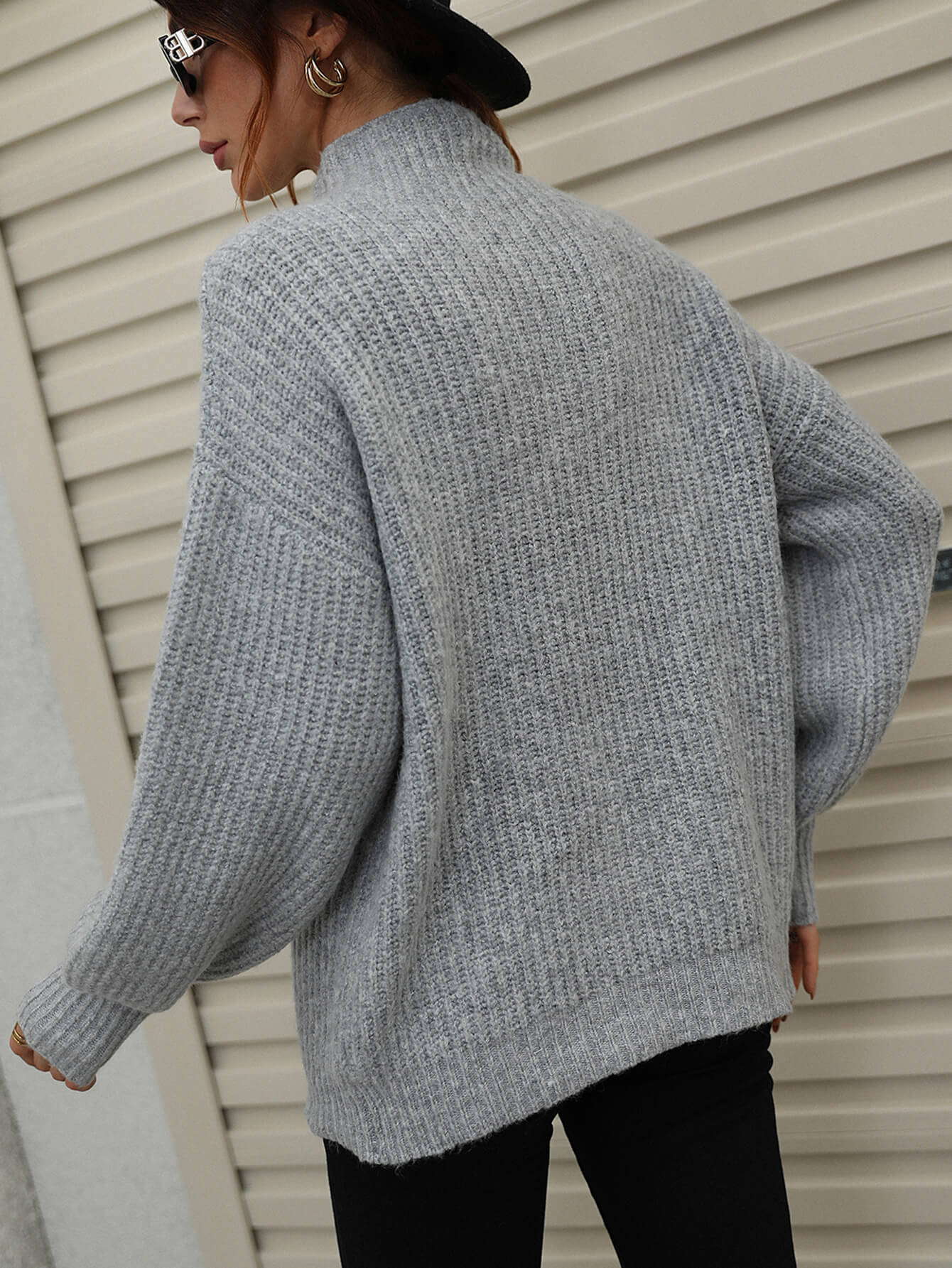 Gray ribbed knit turtleneck sweater with voluminous balloon sleeves.