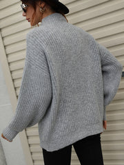 Gray ribbed knit turtleneck sweater with voluminous balloon sleeves.