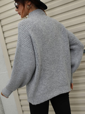 Gray ribbed knit turtleneck sweater with voluminous balloon sleeves.