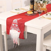 Red table runner with a charming gnome accent, featuring a patterned hat and striped legs.