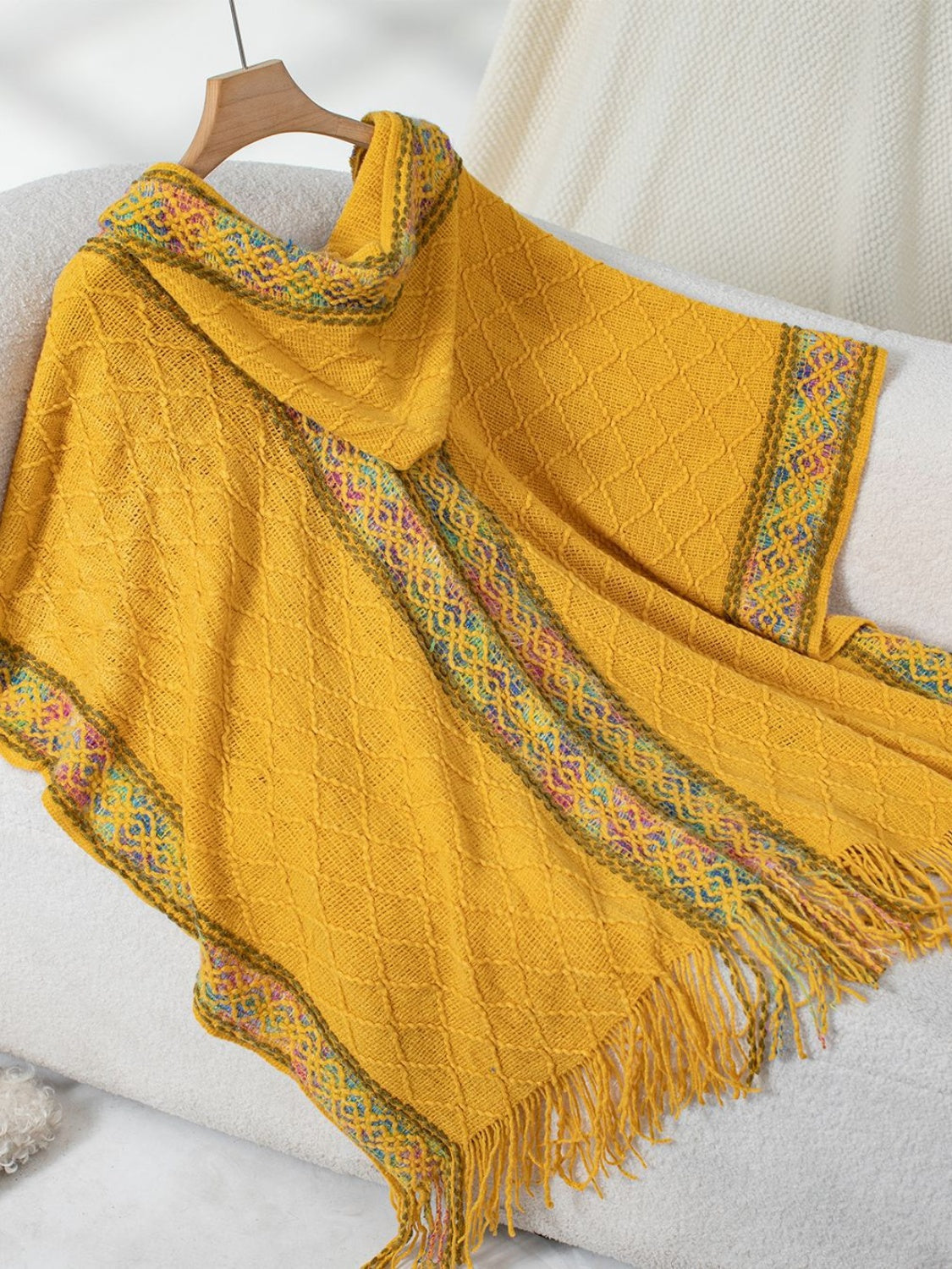 Mustard knit hooded wrap with diamond pattern and colorful embroidered trim.