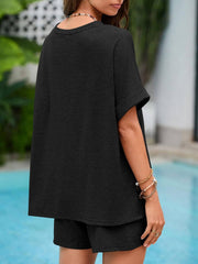 Black relaxed fit tee with cuffed sleeves and matching shorts, casual loungewear set.