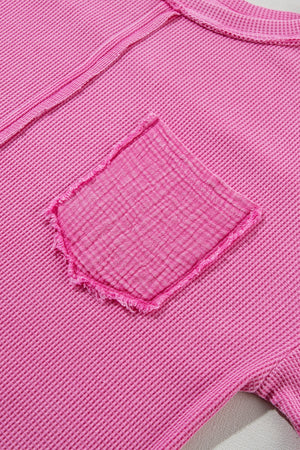 Fuchsia pink waffle knit top with raw seam detail and a deconstructed pocket.