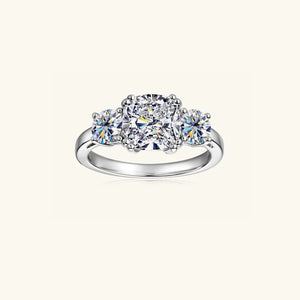 Silver three-stone cushion cut moissanite ring with a central square stone and two round side stones.