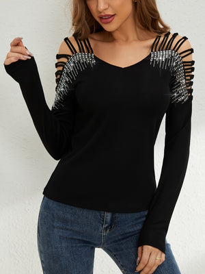 Black ribbed knit blouse with strappy cold shoulder and rhinestone embellishments.