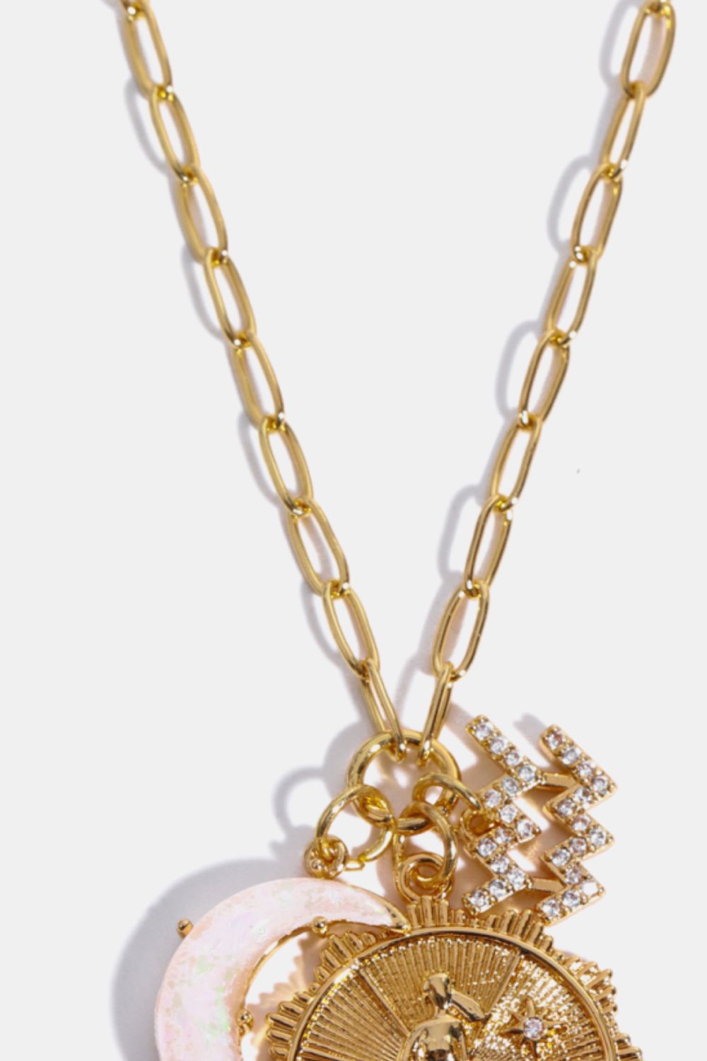 Gold chain pendant necklace with celestial charms including a moon and zodiac symbols.