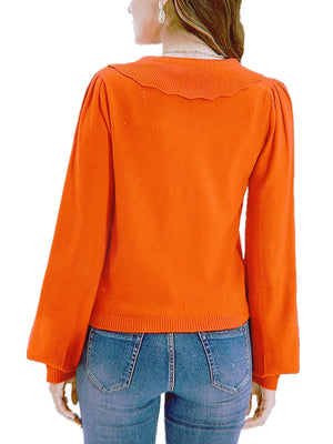 Orange knit cardigan with scalloped collar and puff sleeves