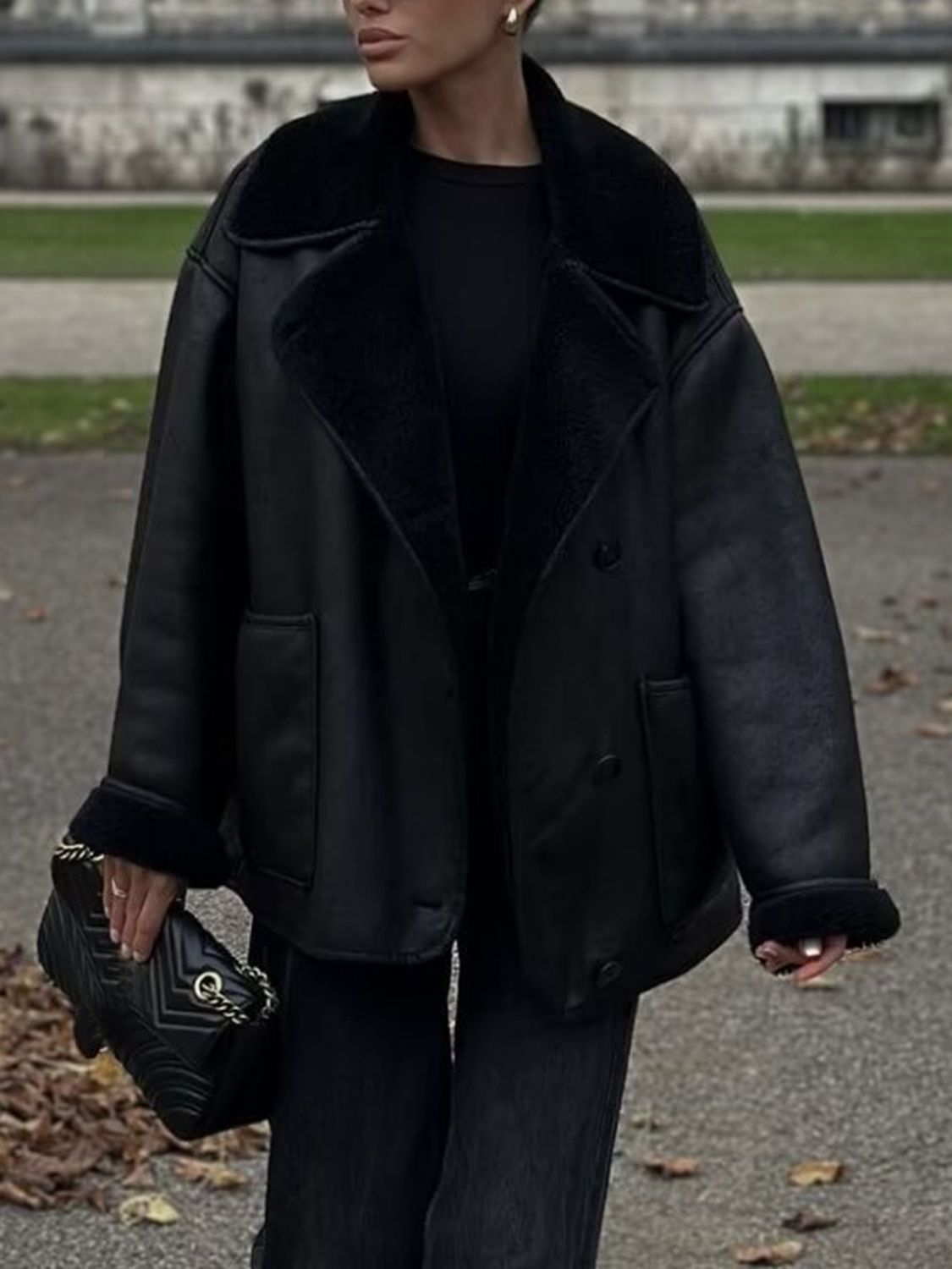 Black oversized aviator jacket with shearling trim and collar, buttoned front, and cuffed sleeves.