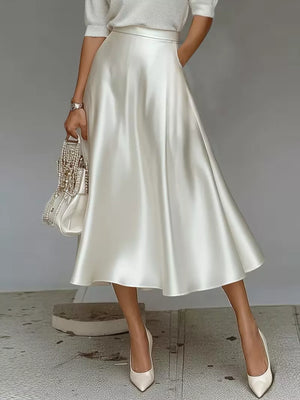 Elegant white satin A-line midi skirt with pockets and a flowing silhouette.