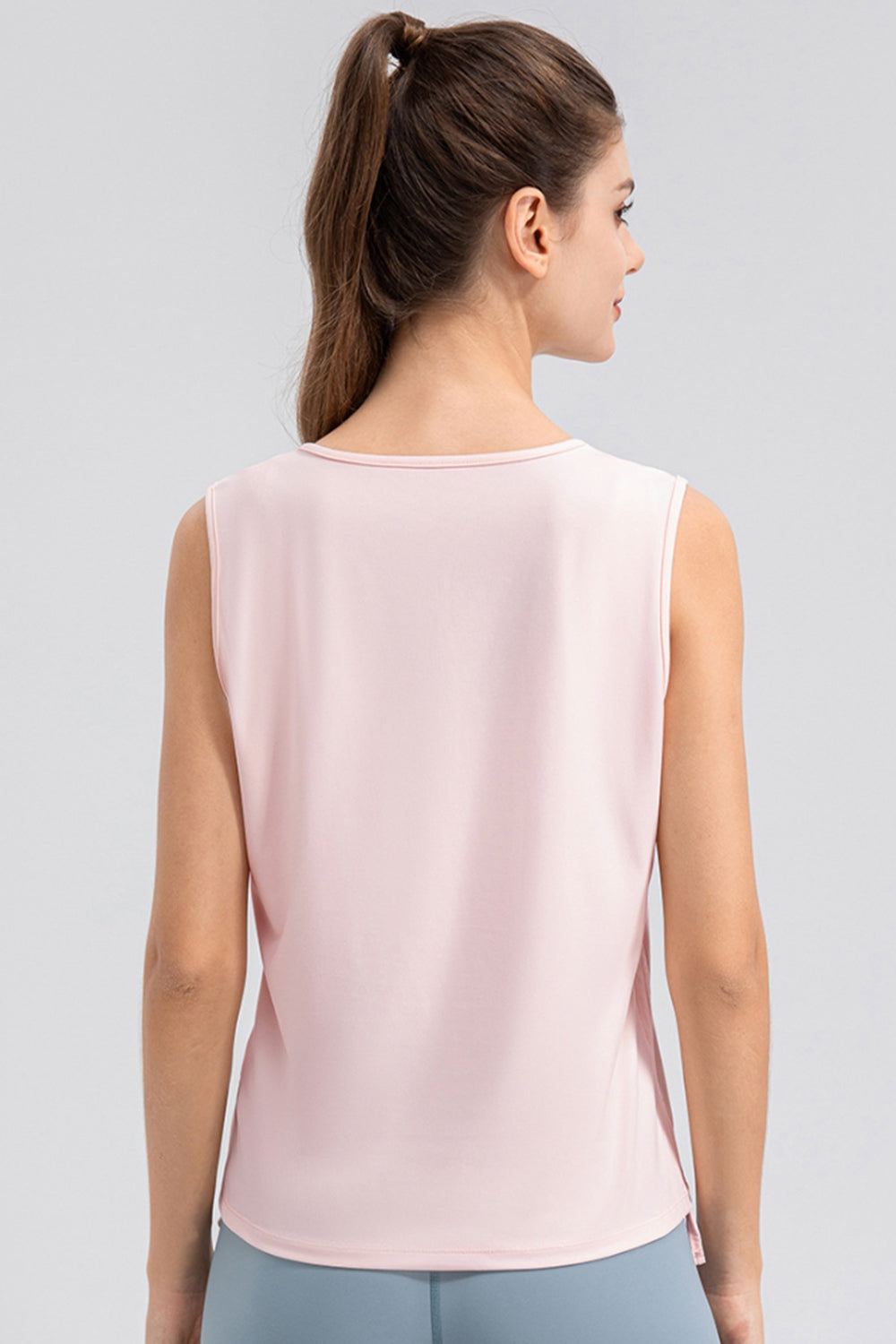 Blush pink active tank top with notched neckline and sleeveless design.