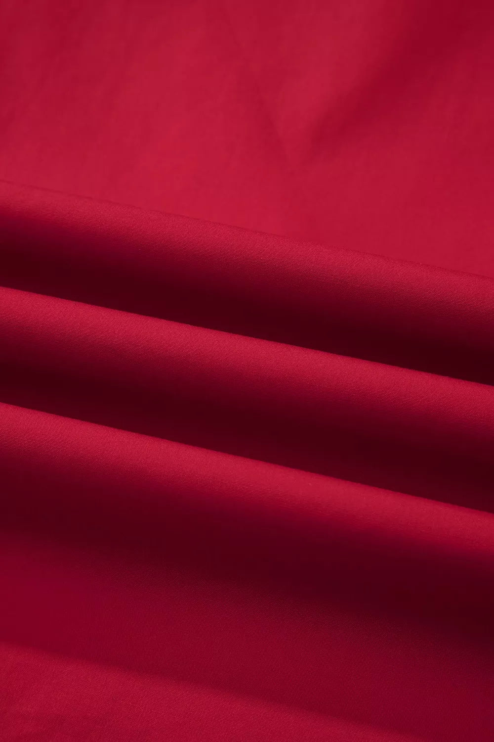 Red cotton maternity blouse with ruffled detail and notched neckline.