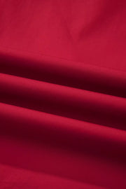 Red cotton maternity blouse with ruffled detail and notched neckline.