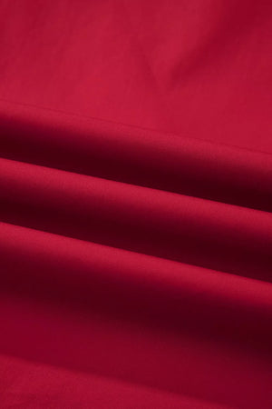 Red cotton maternity blouse with ruffled detail and notched neckline.