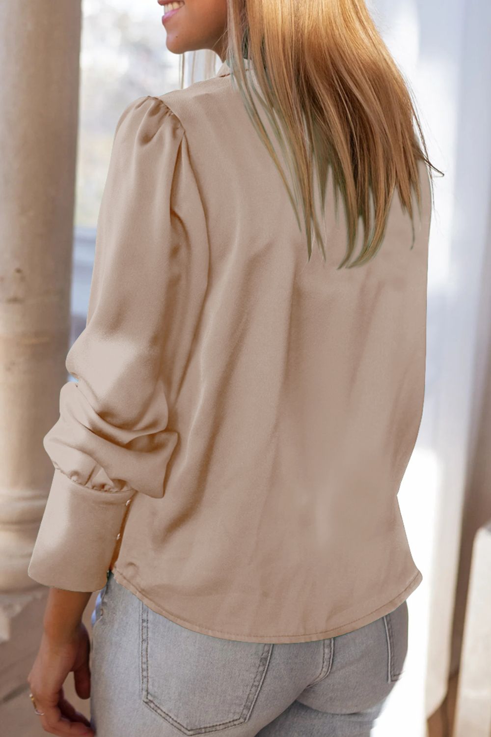 Tan satin blouse with poet sleeves and buttoned cuffs.