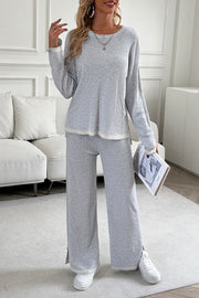 Light gray ribbed knit lounge set with contrast trim and side slit pants.