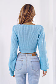 Pastel blue acrylic knit crop sweater with balloon sleeves and tie front detail.