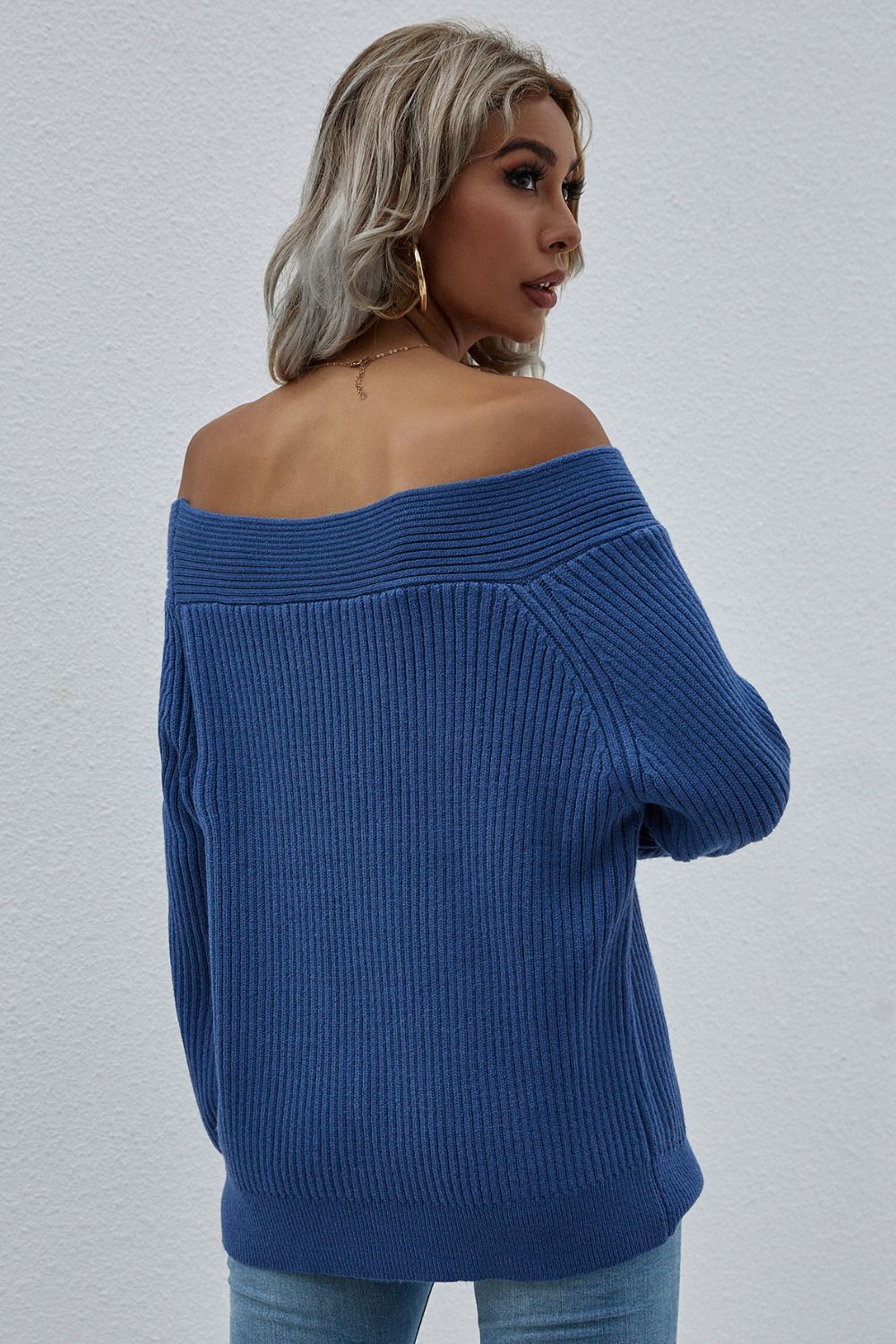 Blue ribbed knit sweater with off-the-shoulder neckline and long sleeves.