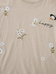 Beige cotton tee with embroidered daisies, butterflies, and "happy" text.