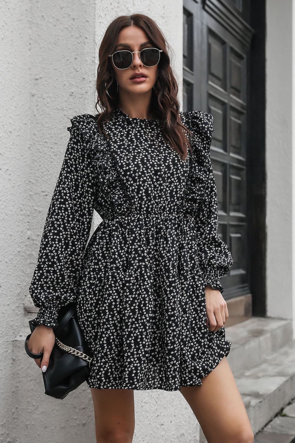 Black dot print dress with ruffle trim, long sleeves, and cinched waist.