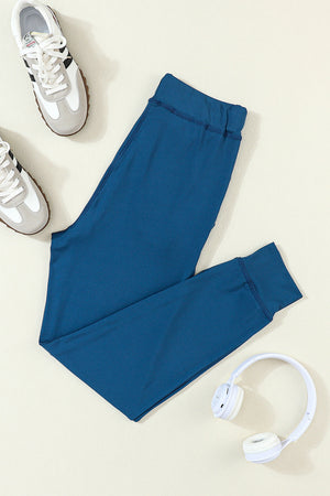 Slim-fit dark blue joggers with drawstring waist and cuffed ankles.