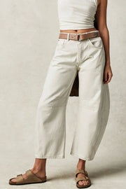 Cream barrel leg jeans with contrast stitching and a brown belt.