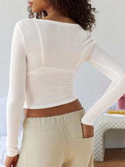 Cream ribbed crop top with long sleeves and a scoop neck, shown from the back.