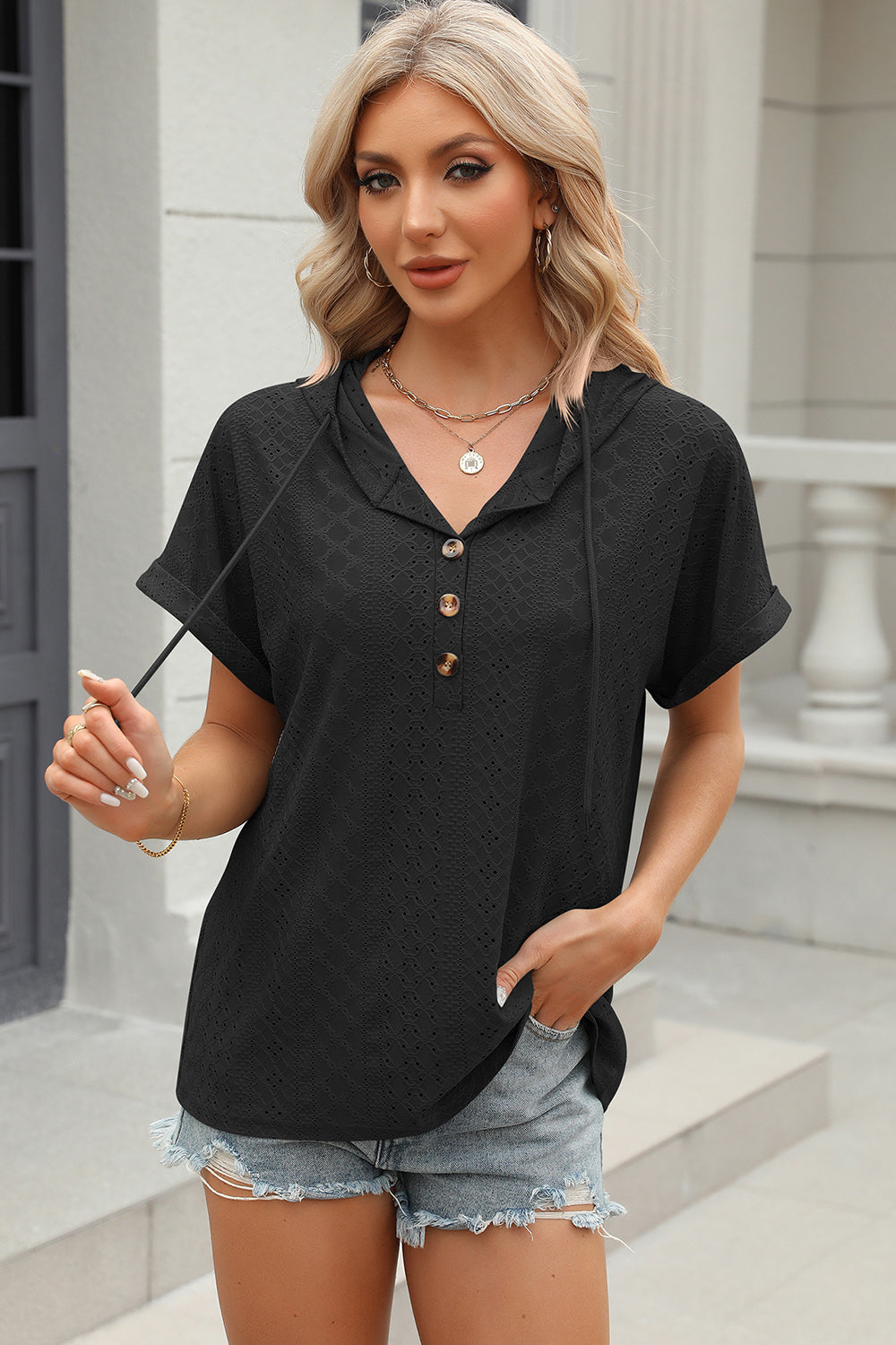 Black perforated henley hooded tee with short sleeves and button placket.